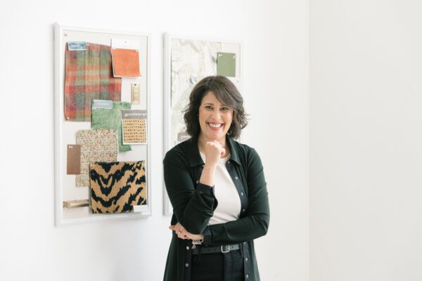 Interior Designer smiling at camera with fabric and mood board in background 