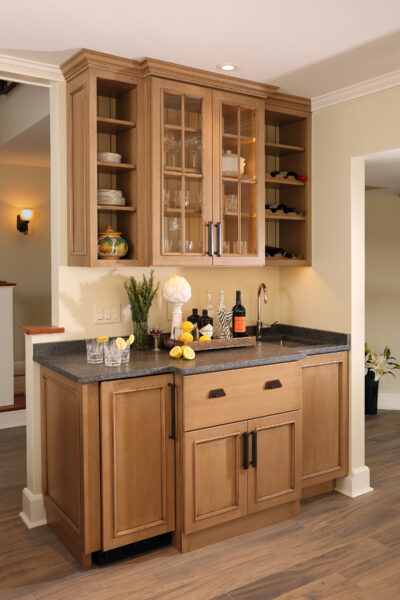 Wet Bar with sink and beverage fridge warm wood and black counter. Change orders, add-ons and unforeseen project expenses.  
